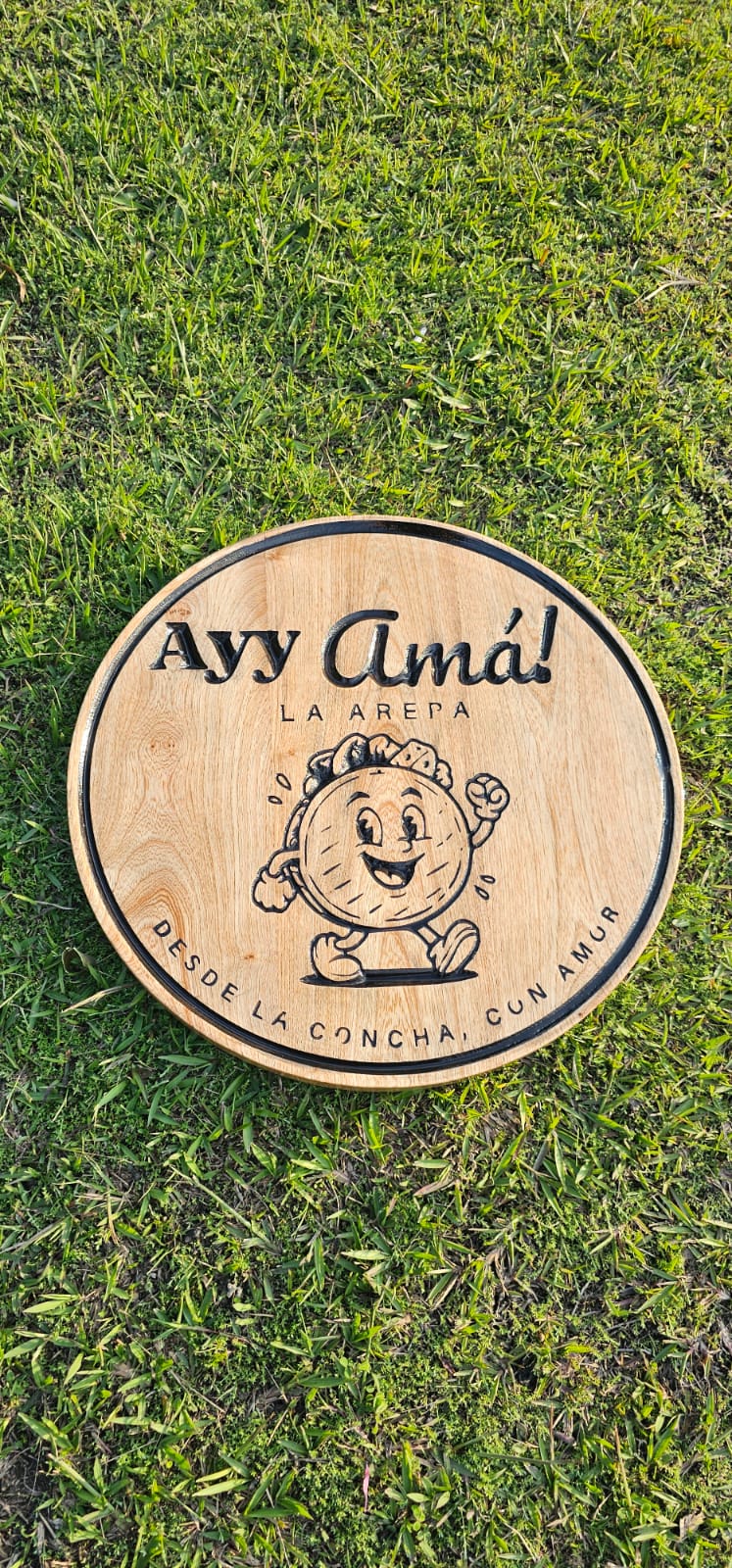 Logo Ayy Amá la Arepa grabado en madera circular